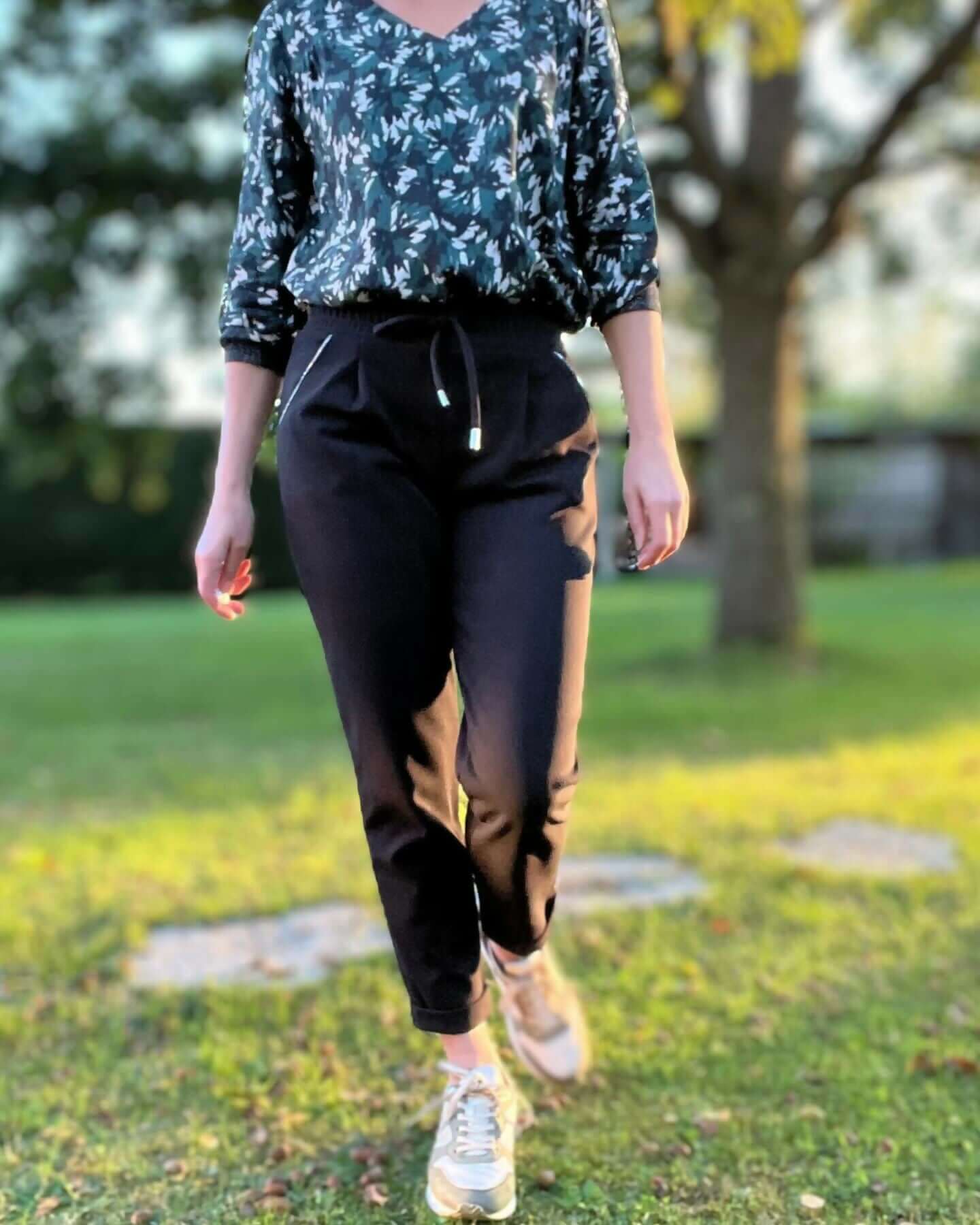 Femme portant le pantalon Sprint, coupe carotte, look sportif et élégant en milieu urbain.