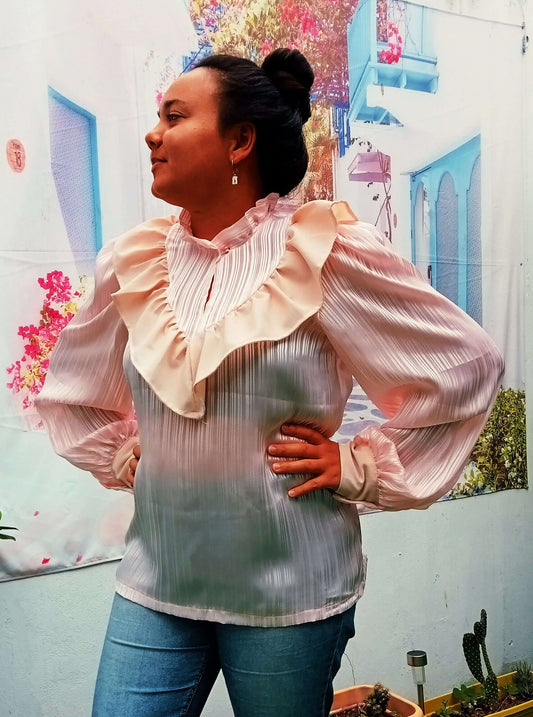 Femme portant une blouse à col montant froncé, manches Bishop et volant, mode estivale.