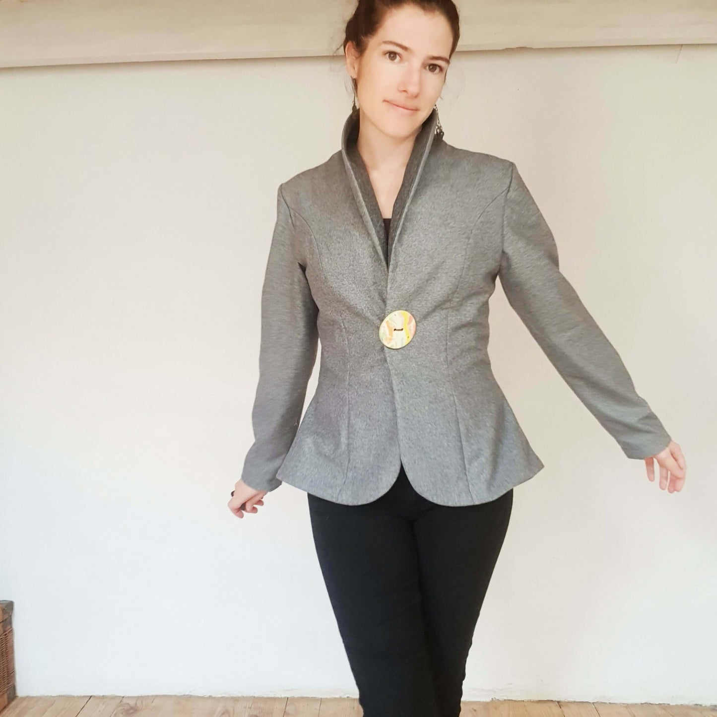 Femme portant la veste "Arybelle", col châle, style cintré avec bouton, couleur grise, élégante pour la demi-saison.