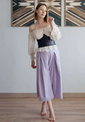 Femme portant un pantalon dans un intérieur moderne, accessoire parfait pour Pantalon - XXS-/XL - VINTAGE CADILAC, patron de couture pdf à télécharger.