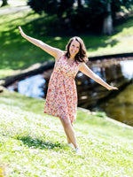 Femme portant AIRELLE - La robe / blouse aux 1000 versions, patron de couture PDF à télécharger, dans un parc ensoleillé.