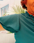 Détails de la blouse Némésis avec col froncé et manches courtes volantées, parfaite pour l'été.