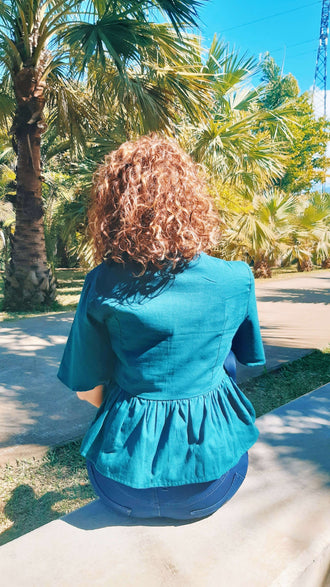 Vue arrière de la Blouse Théia - T36 à 50 en extérieur, mettant en valeur le design péplum. Patron de couture pdf à télécharger.