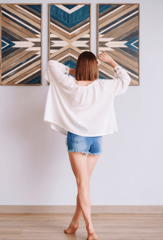 Vue arrière d'une femme portant un blouse patron de couture pdf à télécharger, Blouse - XS-XXXL - JENNIFER, devant des tableaux abstraits.