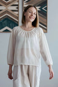 Blouse - XS/XL - WONDERELA, patron de couture pdf à télécharger, femme portant une blouse blanche élégante dans un intérieur moderne.