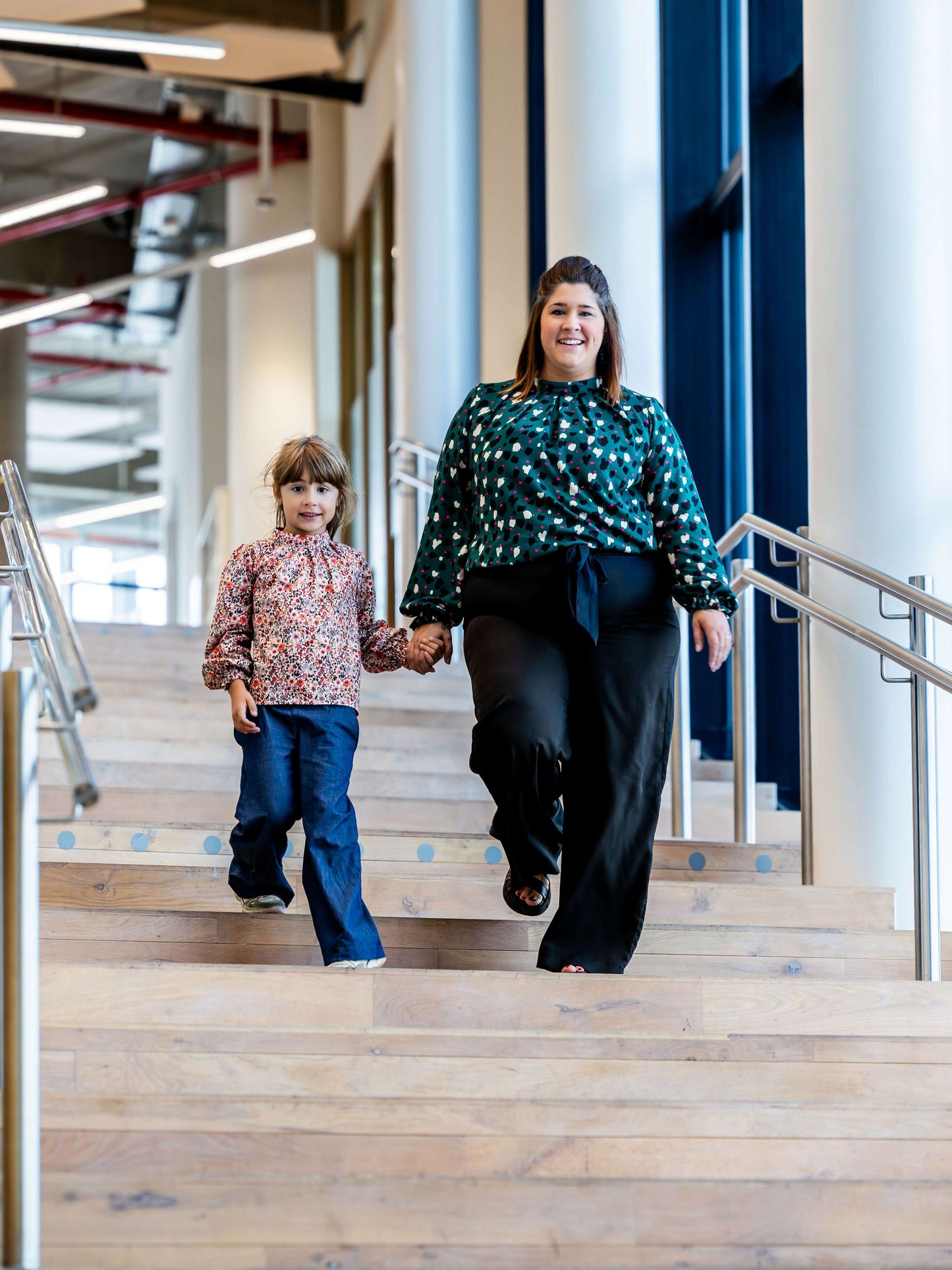 Deux personnes descendant des escaliers, mettant en valeur CERISE - la blouse/robe à plis. Patron de couture pdf à télécharger.