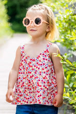 Enfant portant CLEMENTINE - Le top et la robe d'été, patron de couture pdf à télécharger, vêtement fleuri, lunettes de soleil roses.