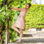 Femme portant la CLEMENTINE - Le top et la robe d'été, patron de couture pdf à télécharger, dans un jardin ensoleillé