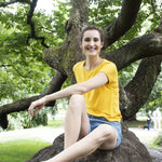 Femme souriante portant le t-shirt CRANBERRY - Le t-shirt pour toute la famille, patron de couture pdf à télécharger, assise dans un parc.