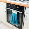 Essuie-main Miss Cactus accroché à une poignée de four, idéal pour la cuisine. Patron de couture pdf à télécharger.