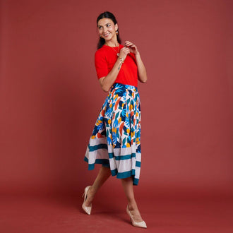 Femme portant la Jupe La Prodigieuse - T34 à 48, patron de couture pdf à télécharger, dans un décor festif et coloré.