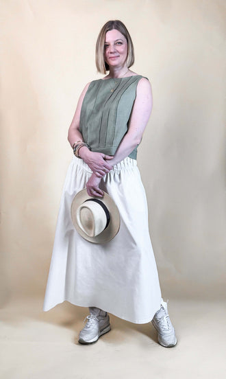 Modèle féminin portant une Jupe Lola, patron de couture pdf à télécharger, avec un haut vert kaki et des baskets blanches.