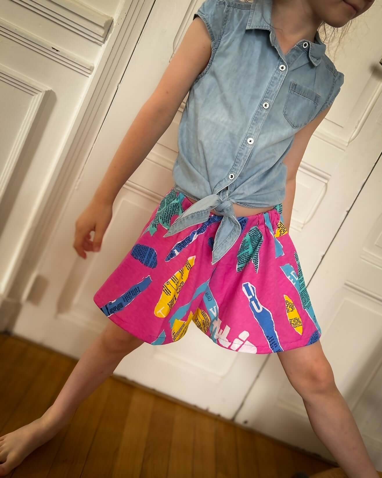 Fille portant un jupe-short coloré avec un haut en jean, prête pour l'été et les activités de plein air.