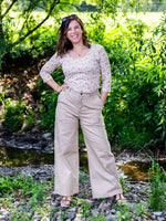 Femme portant KAKI - Le pantalon chino beige dans un cadre naturel, parfait pour toutes morphologies, patron de couture pdf à télécharger.