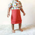 Enfant portant une robe "LITCHI : t-shirt, sweat et robe en un patron", patron de couture pdf à télécharger, motif floral coloré.