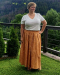 Femme portant la jupe EOLYA du 32 au 52, patron de couture pdf à télécharger, en plein air sur une terrasse verdoyante.