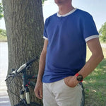 Le Polo Enjoy Homme du 38 au 50 porté en extérieur près d'un vélo, idéal pour un look décontracté.