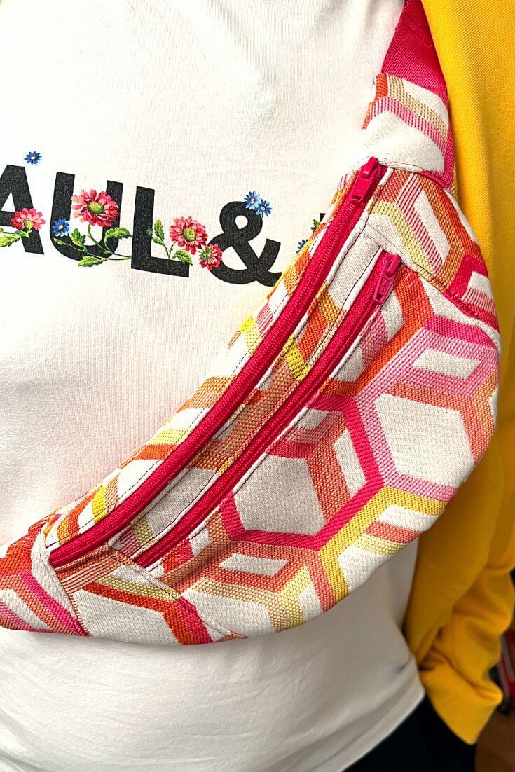 Patron de couture à télécharger pour sac banane coloré géométrique porté sur t-shirt blanc fleuri et sweat jaune