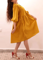 Femme portant la MIMA robe-taille de 30à 58 EU, patron de couture pdf à télécharger. Élégance et confort avec manches bouffantes et poches.