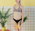 Maillot de bain - XS/L - BREATH avec patron de couture PDF à télécharger, modèle avancé présenté par une femme tenant des fleurs, fond jaune.