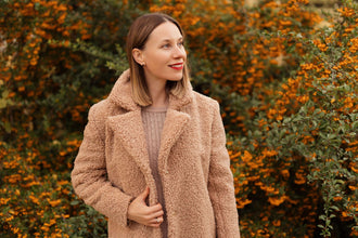 Femme portant un manteau - XS|L - Fluffy Love, patron de couture pdf à télécharger, entourée de feuillage automnal.