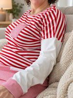 Patron PDF Pyjama femme NOVA du 34 au 60, rayé rouge et blanc, porté assis sur canapé gris