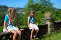 Enfant portant le Short Coquelicot en coton blanc à motifs rouges, assis en extérieur face à la nature