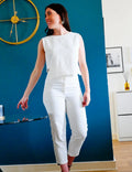 Femme portant le Pantalon Alta, patron de couture pdf à télécharger, élégant et décontracté, contre un mur bleu.