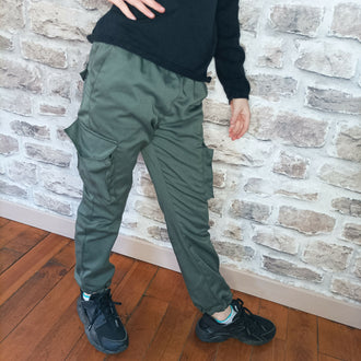 Enfant portant le Pantalon Enfant LAST, pantalon cargo tendance avec taille élastiquée. Disponible en patron de couture PDF à télécharger.