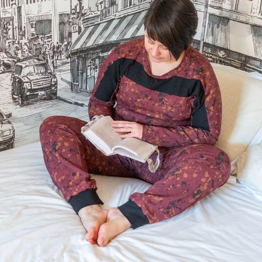 Femme lisant en pyjama sportwear "Pantalon pyjama sportwear, 34 au 56, 4 statures – Camomille", patron de couture pdf à télécharger.