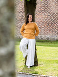 Femme portant le Patron PDF Blouse Bénitier PINA COLADA, manches longues en coton jaune moutarde et pantalon blanc fluide