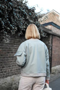 Femme portant le Patron PDF Bomber Arthur du 34 au 44, vue de dos dans une ruelle pavée