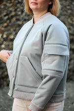 Femme portant le Patron PDF Bomber Arthur du 34 au 44, vue de côté, en jersey gris clair avec poches plaquées