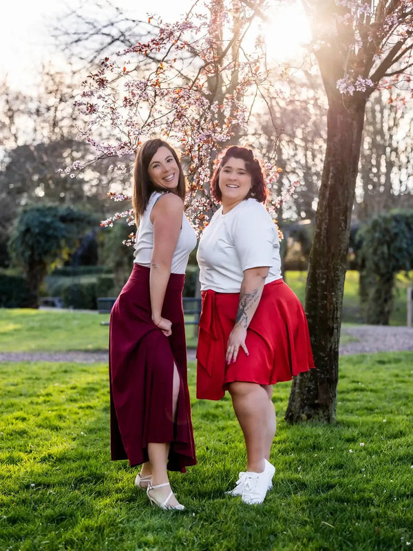Deux femmes portant des jupes élégantes dans un parc fleuri, illustrant le Patron PDF Jupe NOISETTE Femme/Enfant, patron de couture pdf à télécharger.