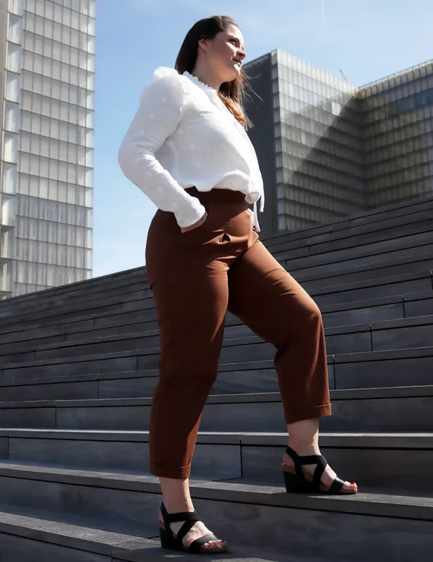 Femme portant le Patron PDF Pantalon Jasmin en velours caramel, vue de profil en milieu urbain