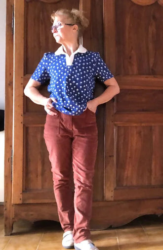 Femme portant le Patron PDF Pantalon Q du 32 au 60 en velours rose, vue de face devant portes en bois