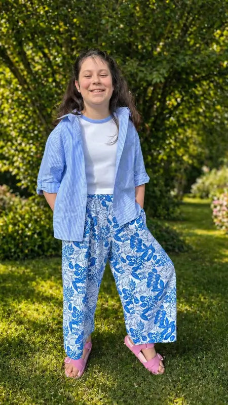Enfant portant un Pantalon Rigotte, patron de couture PDF à télécharger, disponible du 12 mois au 14 ans, dans un jardin verdoyant.