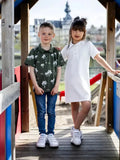 Patron PDF Polo multi-manches Kiwi, enfant portant le modèle en vert à motifs, vue de face en coton