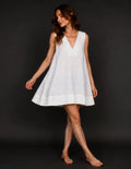 Femme portant le Patron PDF Robe LARA du 30 au 58, robe blanche lin col V sans manches, coupe ample et évasée, tombé fluide