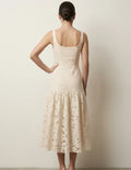 Femme portant le Patron PDF Robe ROSALI du 30 au 58, vue de dos en broderie anglaise crème, coupe ajustée avec basque évasée
