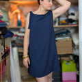 Femme portant le Patron PDF Robe Néris du 32 au 52, robe droite marine sans manches, vue de profil en atelier