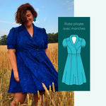 Femme portant le Patron PDF Robe Pelagia du 32 au 52, robe portefeuille manches courtes en velours bleu, dans un champ de blé