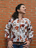 Femme portant le Patron PDF Sweat ALPIN Adulte du XXS au 6XL, modèle floral, devant un mur de briques, patron de couture pdf à télécharger.