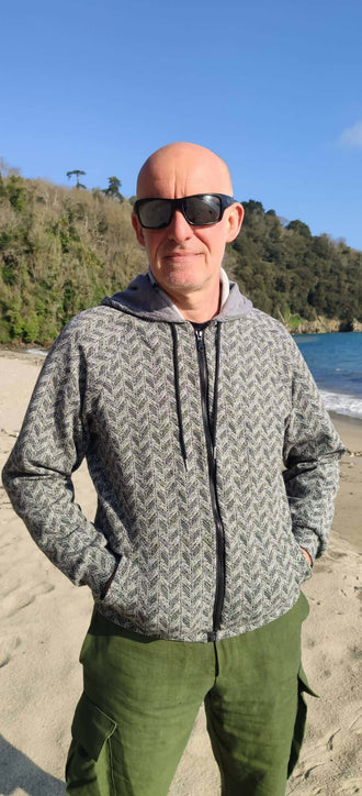 Homme portant le Patron PDF Sweat ALPIN Adulte du XXS au 6XL sur une plage, sweat technique et modulable avec ouverture zippée.