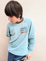 Enfant portant un sweat turquoise avec le texte "Ordinateur j'accepte les cookies" imprimé sur le devant.