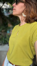 Femme portant le Patron PDF T-Shirt Femme Zestia, encolure fendue, en jersey jaune anis, vue de profil en extérieur