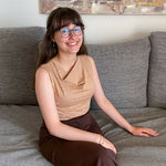 Femme portant le Patron PDF T-Shirt col bénitier sans manche Mandarine, vue de face assise sur un canapé gris