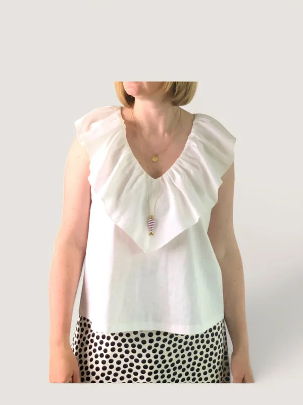 Femme portant le Patron PDF Top Line du XS au XXL, top blanc à volant, associé à un bas à pois noirs