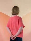 Femme portant le Patron PDF Top Luca du XS au XXL, manches courtes en coton, vue de dos sur fond géométrique pastel