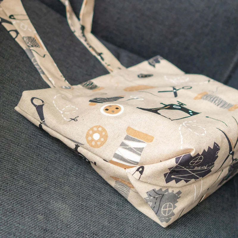 Petit Tote Bag avec fond en coton imprimé, détails de couture visibles, posé sur tissu gris